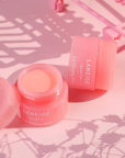 two Berry Lip Sleeping Mask Balm on a pink background